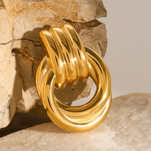 Elegant geometric gold stainless steel brooch displayed on natural stone background