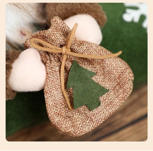 Detail of burlap gift bag with green felt Christmas tree on a plush holiday stocking