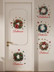 Detailsicht der Weihnachts-Wandaufkleber mit Kranz und Bathroom-Schild an weißer Tür