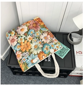 Detail of colorful floral embroidery and thick cotton rope handles on canvas tote bag