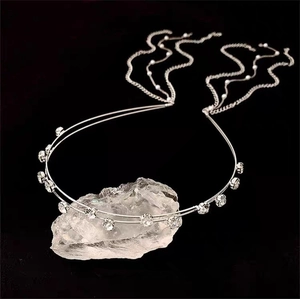 Detail view of silver double-layered headband with sparkling crystals and long pearl tassels