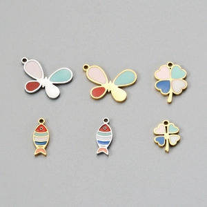 Detail view of gold and silver enamel clover, butterfly, and fish charms for DIY jewelry