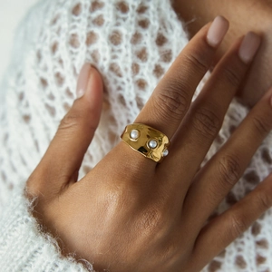 Détail de la bague large en acier doré 18K avec trois perles et texture martelée