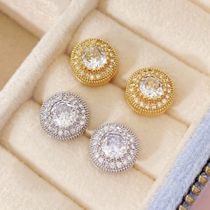 Detail of round flower stud earrings with large central stone and gold silver plating