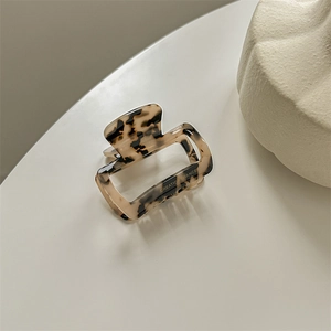 Close-up of tortoise shell pattern on rectangle acetate hair claw with high-gloss finish