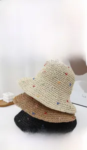 Detail of straw hats with colorful star embroidery and openwork weaving texture