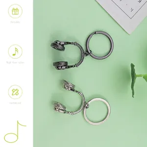 Creative headphone-shaped metal keychains in gun-black and silver on a green background
