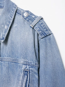 Close-up of light blue denim jacket collar featuring metal buttons and distressed texture