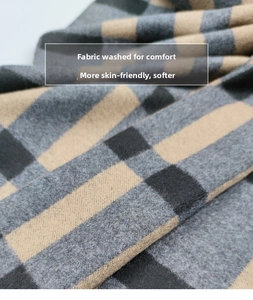 Close-up of soft brushed wool plaid scarf with grey and camel checkered texture