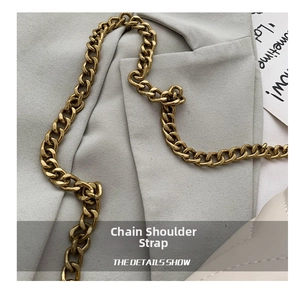 Close-up of vintage golden chain strap on gray suit fabric with refined metal texture