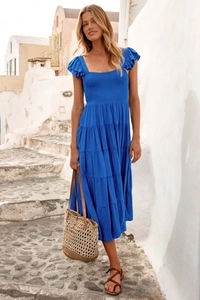 Details des blauen Boho-Kleids mit Rüschenärmeln und gestuftem Rock in der Sonne