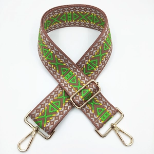 Close-up of geometric woven strap with brown base, green patterns and gold metal clasps