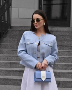 Detail shot of light blue tweed jacket texture and matching blue handbag for women