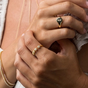 Close-up of gold snowflake ring and diamond bracelet on model hand for daily wear