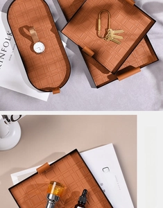 Detail of brown woven leather organizer trays with elegant gold metal frames and handles