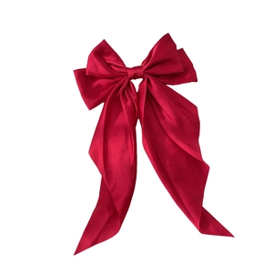 Elegant deep red satin oversized bow hair clip with long ribbons on a white background