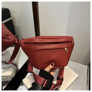Detail of burgundy woven crossbody bag with metal zipper and adjustable strap
