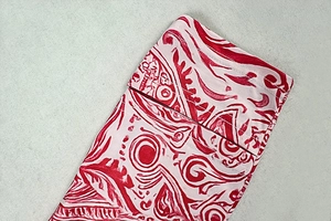 Gros plan d'un tissu abstrait rouge et blanc avec détails de couture à double rangée