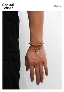 Detailopname van een gouden Hamsa-hand en boze oog armband gedragen op de pols