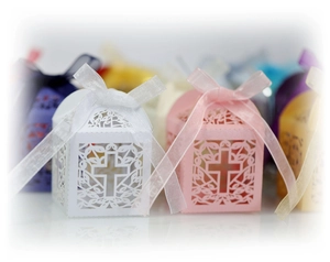 Macro shot of laser-cut cross hollow candy boxes with elegant matching ribbons
