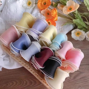 Chiffon ribbon with pearl edges in various colors displayed in a rustic basket
