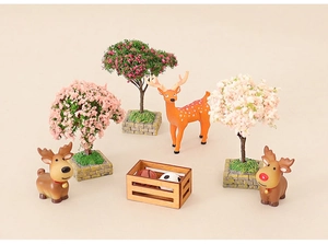 Miniature dollhouse Christmas forest scene with blooming trees and cute deer figurines