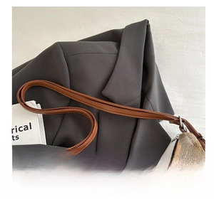 Detail view of the brown plaid tote bag featuring a comfortable handle and silver metal hardware