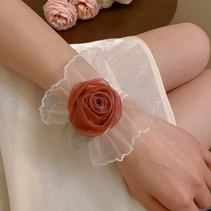 Détail d'un élégant bracelet fleur en soie orange brûlé avec bordure en dentelle
