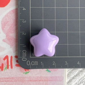 Macro view of purple star resin accessory measured on a grid for DIY phone case crafts