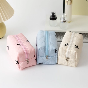 Quilted cotton cosmetic bags with black bow embroidery in pink, blue, and off-white set