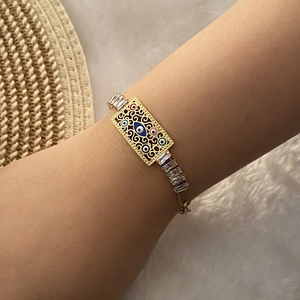 Golden stainless steel evil eye bracelet with hollow patterns and cubic zirconia on wrist