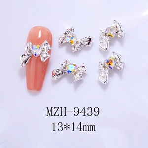 Silver bow heart nail charms 13x14mm shown on long pink fake nail for DIY manicure