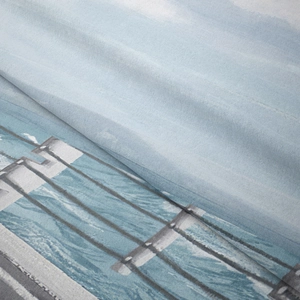 Close-up of soft fabric texture featuring a scenic coastal boardwalk and ocean print