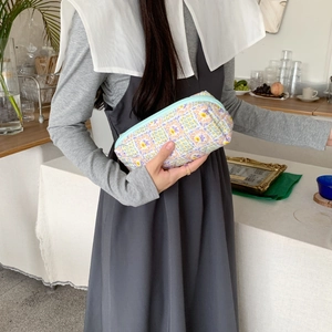Pochette per cosmetici in cotone trapuntato con stampa floreale e cerniera blu tenuta a mano