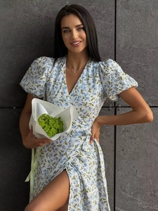 Detail of light blue floral wrap dress showing waist tie and puff sleeve textures