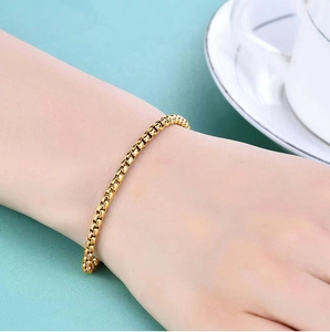 Close-up of a 18K gold-plated stainless steel box chain bracelet worn on a wrist
