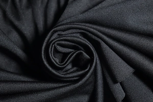 Gros plan sur la texture du tricot noir montrant la structure fine et le drapé fluide