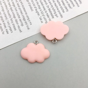 Close-up of two pink resin cloud pendants with metal loops for DIY jewelry making