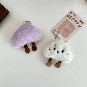 Close-up of soft plush mushroom charms in purple and white on a bag with metal chains