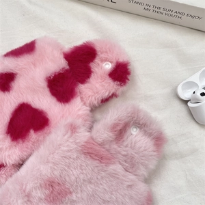 Detail of plush heart-patterned pouch showing soft texture and functional snap fastener