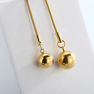 Detail of adjustable gold snake chain featuring two polished solid bead pendants