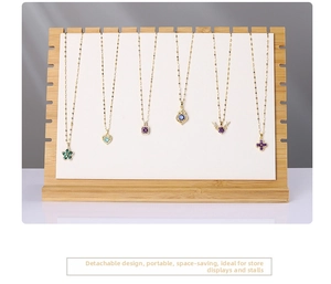 Close-up of bamboo jewelry display stand showing multiple gold necklace pendants