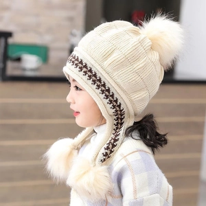 Cappello in maglia beige per bambina con paraorecchie e pompon per l'inverno