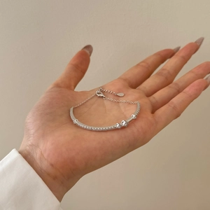 Detail of silver Mobius bracelet with inset zircons and opal on a model's wrist