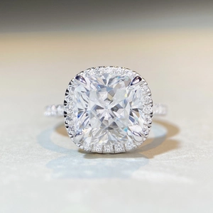 Macro shot of cushion-cut moissanite ring with side diamonds and silver plating