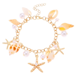 Bohemian gold seashell bracelet with pearls and starfish charms on a white background
