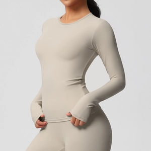 Détail du haut de sport beige montrant les poignets passe-pouce et le tissu extensible