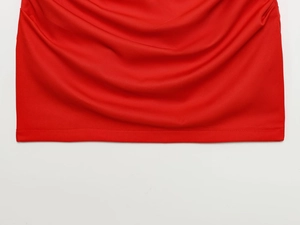 Détail de la texture du tissu en maille rouge avec des drapés et plis élégants