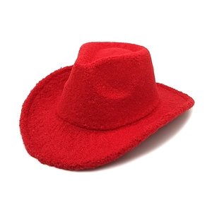 Close-up of red western cowboy hat made of textured faux lamb wool fabric