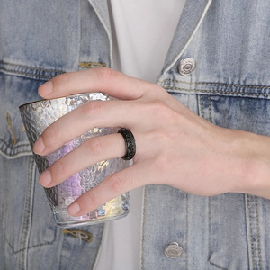 Close-up of a punk style black rotatable ring with skull and cross reliefs on hand